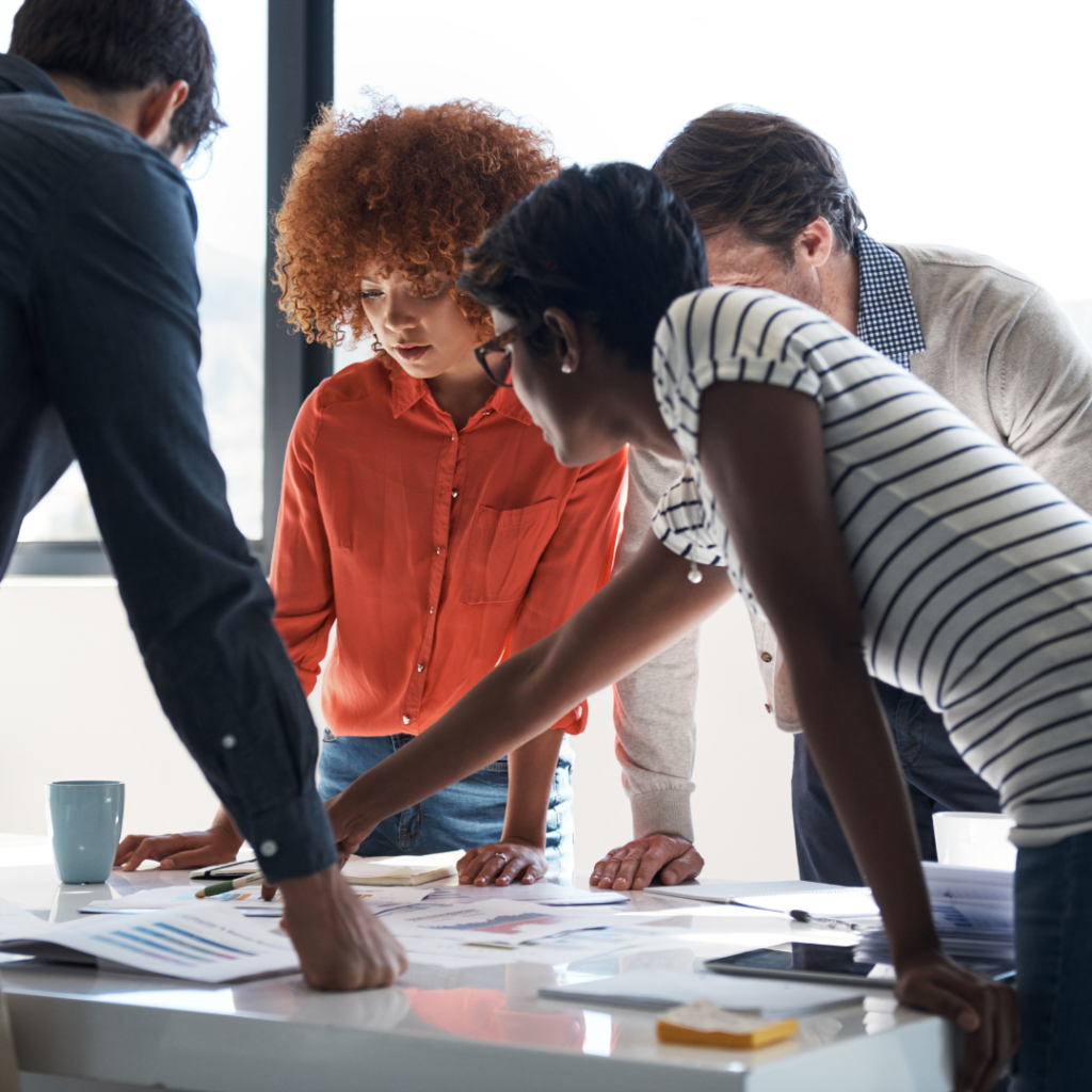 A group of people looking over paperwork on a table.